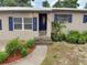 Close-up shot of the inviting front entrance with a blue door and landscaped garden at 5615 Arundel Dr, Orlando, FL 32808