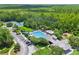 Aerial view of a community pool with a clubhouse, tennis courts, playground, and ample parking at 660 Celebration Ave # 250, Kissimmee, FL 34747