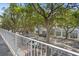 Balcony view overlooking a charming street lined with trees and parked cars on a sunny day at 660 Celebration Ave # 250, Kissimmee, FL 34747