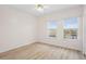 Well-lit bedroom with wood floors and two bright windows overlooking neighborhood at 660 Celebration Ave # 250, Kissimmee, FL 34747