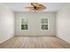 Bright bedroom showcasing light wood floors and two windows offering natural light at 660 Celebration Ave # 250, Kissimmee, FL 34747
