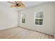 Bright bedroom featuring hardwood floors, two windows with blinds, and a modern ceiling fan at 660 Celebration Ave # 250, Kissimmee, FL 34747