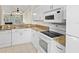 White kitchen with stainless appliances, granite counters, ceiling fans, and a breakfast bar at 660 Celebration Ave # 250, Kissimmee, FL 34747