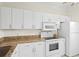 Updated kitchen with white cabinets, granite countertops and stainless steel microwave and refrigerator appliances at 660 Celebration Ave # 250, Kissimmee, FL 34747