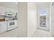Bright kitchen featuring all-white cabinets and appliances with granite countertops and an adjacent entryway at 660 Celebration Ave # 250, Kissimmee, FL 34747