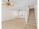 Open-plan living room boasting wood floors, leading to staircase and kitchen at 660 Celebration Ave # 250, Kissimmee, FL 34747