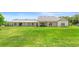 Expansive backyard view featuring a modern home with a covered patio and lush green lawn at 700 Old Geneva Rd, Geneva, FL 32732