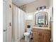 Well-lit bathroom features a shower with tile surround, granite countertop, and wood vanity at 700 Old Geneva Rd, Geneva, FL 32732