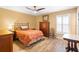 Cozy bedroom with wood-look floors, ceiling fan, and ample natural light from the window at 700 Old Geneva Rd, Geneva, FL 32732