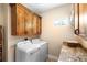 Bright laundry room with wooden cabinets, washer, dryer, and countertop space at 700 Old Geneva Rd, Geneva, FL 32732