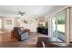 Cozy living room with leather furniture, TV, ceiling fan, decor and a sliding glass door leading to outdoor space at 700 Old Geneva Rd, Geneva, FL 32732