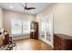 Bright office space with hardwood floors, a ceiling fan, French doors and natural light from the window with white shutters at 700 Old Geneva Rd, Geneva, FL 32732