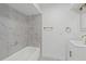 Bright bathroom featuring a tub with stylish marble-look surround and modern vanity with gold fixtures at 7331 Blue Jacket W Pl, Winter Park, FL 32792