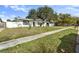 Inviting home with a manicured lawn, mature trees, and a walkway leading to the front door at 7331 Blue Jacket W Pl, Winter Park, FL 32792