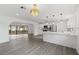 Open-concept kitchen and living area with hardwood floors, pendant lighting, and stainless steel appliances at 7331 Blue Jacket W Pl, Winter Park, FL 32792