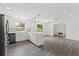 Bright kitchen and living area, with hardwood floors, stainless steel appliances, granite countertops, and modern lighting at 7331 Blue Jacket W Pl, Winter Park, FL 32792
