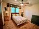 Cozy bedroom featuring a floral bedspread, ceiling fan, and warm, inviting lighting at 8547 Cedar Cove Dr, Orlando, FL 32819