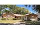Charming single-story home featuring stone accents, mature landscaping, and an attached two-car garage at 8547 Cedar Cove Dr, Orlando, FL 32819