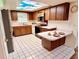 Functional kitchen features wooden cabinets, white appliances, breakfast bar, and unique sky light at 8547 Cedar Cove Dr, Orlando, FL 32819
