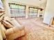 Spacious living room with plush carpeting, staircase, and natural light streaming from large windows at 8547 Cedar Cove Dr, Orlando, FL 32819