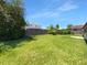 Large grassy backyard with a wood fence and mature trees, perfect for outdoor activities and privacy at 9744 Tattersall Ave, Orlando, FL 32817