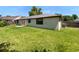 Expansive backyard with well-maintained lawn, featuring a view of the home's exterior and ample space at 9744 Tattersall Ave, Orlando, FL 32817