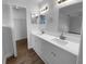 Bathroom with dual sinks, white vanity, ample lighting, and access to the walk-in closet at 9744 Tattersall Ave, Orlando, FL 32817