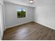 A bright bedroom with wood-look flooring and a large window with great natural light at 9744 Tattersall Ave, Orlando, FL 32817