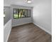 Light-filled bedroom with wood-look floors and a large window offering views of the neighborhood at 9744 Tattersall Ave, Orlando, FL 32817