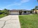 Well maintained one-story home with a beautiful front yard, a two car garage, and lush green grass at 9744 Tattersall Ave, Orlando, FL 32817