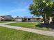 Charming single-story home with a well-manicured lawn and mature trees under a bright blue sky at 9744 Tattersall Ave, Orlando, FL 32817