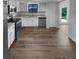 An updated kitchen features granite countertops, white cabinets, stainless steel appliances, and wood-look flooring at 9744 Tattersall Ave, Orlando, FL 32817