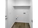 Practical laundry room with washer and dryer hookups, convenient shelving, and laminate flooring at 9744 Tattersall Ave, Orlando, FL 32817