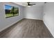 Bright living room with ceiling fan, wood-look flooring, and large window viewing the backyard at 9744 Tattersall Ave, Orlando, FL 32817
