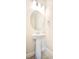 Stylish powder room with a pedestal sink, oval mirror, and modern fixtures at 1023 Sugarwood St, Davenport, FL 33837