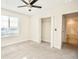 Bright bedroom with large window, ceiling fan, carpet floors, and ensuite bathroom access at 1023 Sugarwood St, Davenport, FL 33837