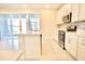 Well-lit kitchen with stone countertops, stainless steel oven, and light cabinetry and ample room for cooking at 1023 Sugarwood St, Davenport, FL 33837