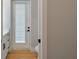 Stylish bathroom featuring wood floors, door to the outside, and white cabinets with dark hardware at 10750 Sw 110Th St, Dunnellon, FL 34432