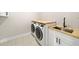 Bright laundry room with a sink and wooden countertops above the washer and dryer at 10750 Sw 110Th St, Dunnellon, FL 34432