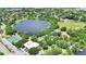 An aerial view of a neighborhood including lake, park, tennis courts, sports field, and playground at 110 Todd Dr, Casselberry, FL 32707