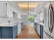 Well-lit kitchen featuring updated appliances, white cabinets, blue trim, and wood flooring at 110 Todd Dr, Casselberry, FL 32707