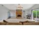 Spacious living room featuring a cozy sofa, stone fireplace, and natural light, creating a warm and inviting space at 110 Todd Dr, Casselberry, FL 32707