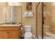 Bright bathroom featuring a glass shower, white toilet, and granite-topped wooden vanity at 1164 Castle Pines Ct, Reunion, FL 34747