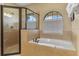 Bright bathroom with a soaking tub and a separate glass-enclosed shower stall at 1164 Castle Pines Ct, Reunion, FL 34747