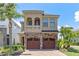 Elegant two-story home with stone accents, arched entry, and a well-manicured lawn at 1164 Castle Pines Ct, Reunion, FL 34747