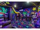 Spacious game room featuring multiple arcade machines and custom neon artwork at 1164 Castle Pines Ct, Reunion, FL 34747