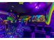 Vibrant game room with arcade machines, neon artwork, and star-patterned flooring at 1164 Castle Pines Ct, Reunion, FL 34747
