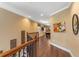 Hallway with wood floors leading to an open game room and other rooms upstairs at 1164 Castle Pines Ct, Reunion, FL 34747