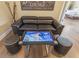 Cozy seating area with a modern black leather couch and interactive smart table game at 1164 Castle Pines Ct, Reunion, FL 34747