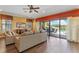 Bright living room featuring sliding glass doors with backyard pool view and comfortable seating arrangement at 1164 Castle Pines Ct, Reunion, FL 34747